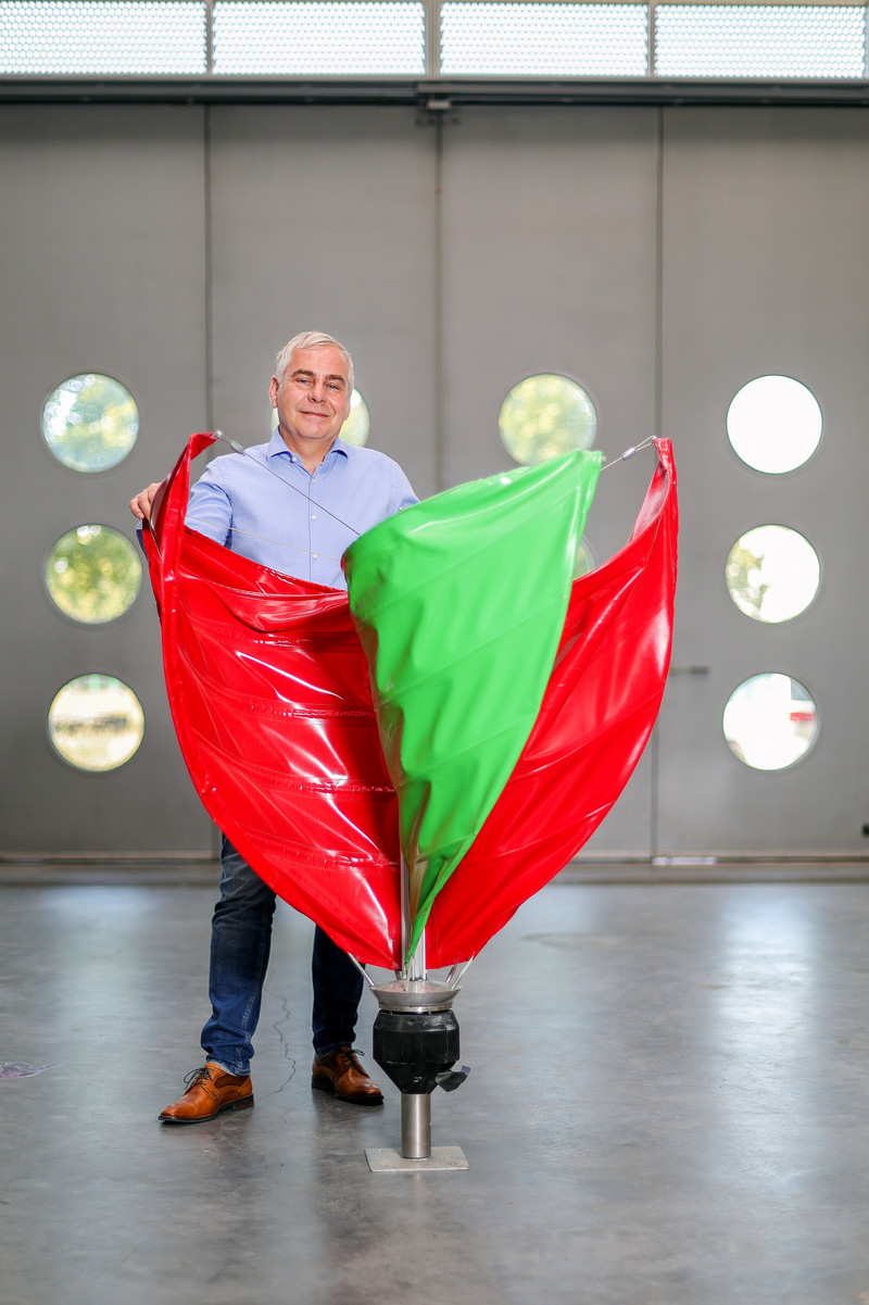 Das Bild zeigt Mario Spiewack mit der Mini-Windkraft-Anlage von SailWindTec GmbH